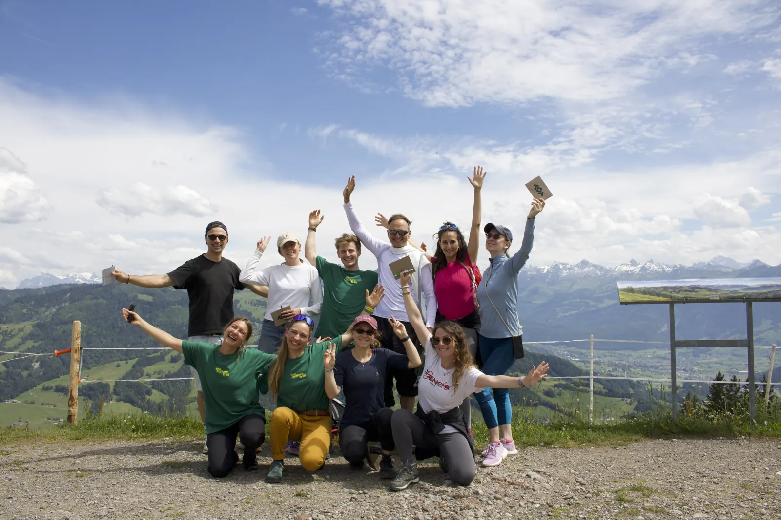 Gruppe von Teilnehmenden mit erhobenen Armen auf dem Trail
