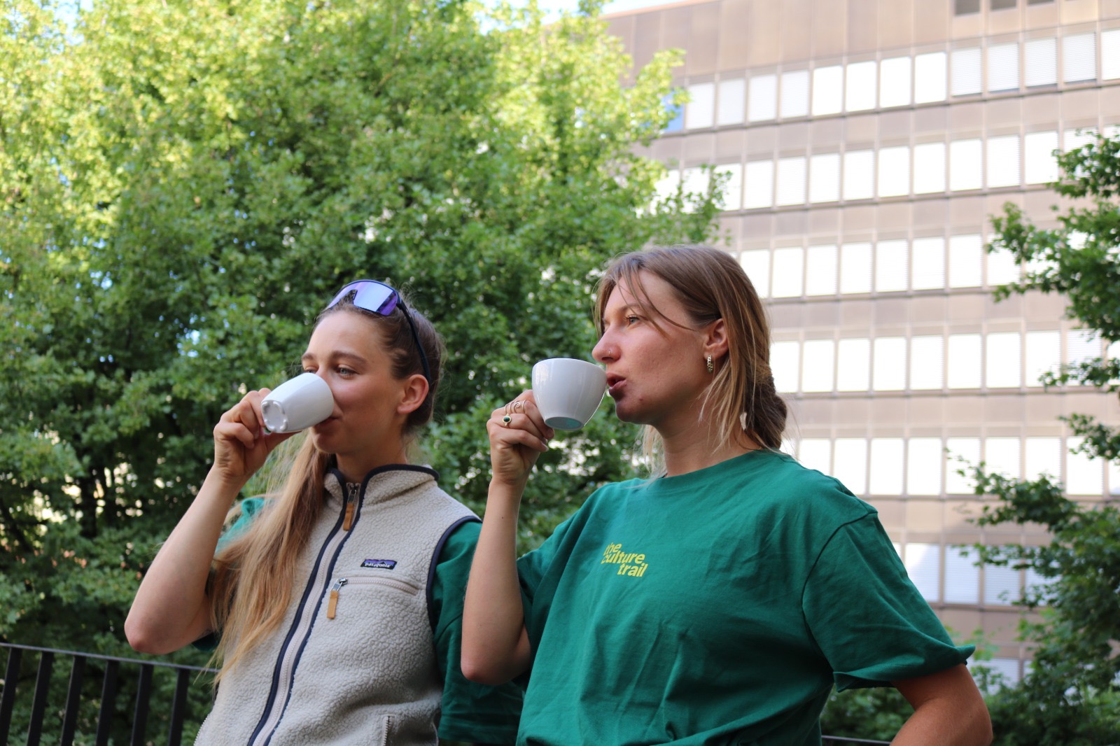 Josien Verkleij und ihr Gegenüber trinken Kaffee in Shirts von The Culture Trail